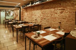 特雷维索罗坎达庞特丹住宿加早餐旅馆的餐厅设有木桌和椅子,拥有砖墙