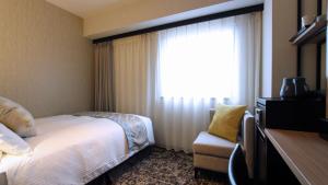 名古屋Best Western Plus Nagoya Sakae的酒店客房设有床和窗户。