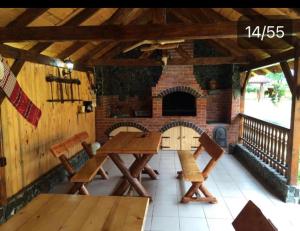 克尔茨什瓦拉乡Pensiunea Bujor de Munte的庭院设有2张桌子和砖砌壁炉