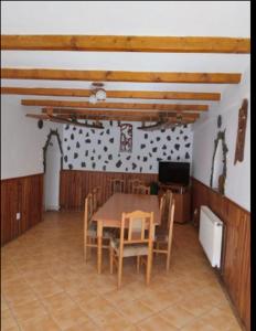 克尔茨什瓦拉乡Pensiunea Bujor de Munte的一间带桌椅和电视的用餐室