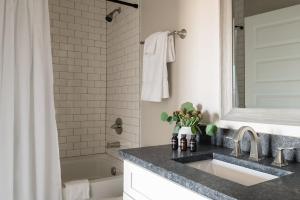 纳什维尔Chesney Rhett by AvantStay Sleeps 20 Spacious Home w Southern Flare的浴室配有水槽、淋浴和浴缸。
