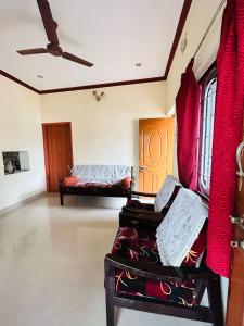 PerambalūrSirvachur madhurakalli amman guest house的客厅配有红色窗帘和沙发