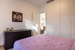 布林迪西Casadamare Salento的卧室配有粉红色的床和梳妆台。
