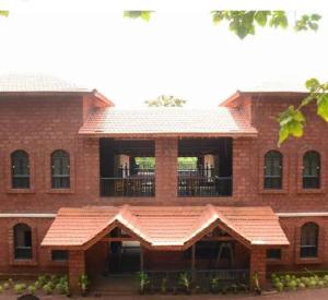 甘帕普拉Konkan Nest Resort的带阳台的大型红砖建筑