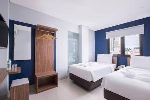三宝垄Gold Hotel Simpang Lima的酒店客房设有两张床和窗户。