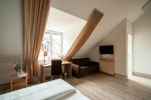 莱茵河畔因格尔海姆瓦塞韦恩酒店的一间卧室配有一张床、一张沙发和一个窗口
