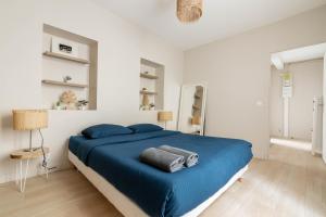 巴黎Luxurious 1 Bedroom Quartier de la Bastille Free Netflix的一间卧室设有蓝色的床和白色的墙壁