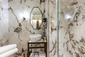 威尼斯阿卡酒店的大理石浴室配有水槽和镜子