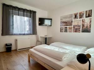 格拉茨sHome CityHouse Graz - Self-Check-in的一间卧室配有两张床和一台平面电视