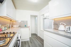吉林汉姆3 bedroom-Contractors-Professionals的厨房配有白色橱柜和炉灶。