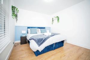 吉林汉姆3 bedroom-Contractors-Professionals的一间卧室配有一张带蓝白色床单的大床