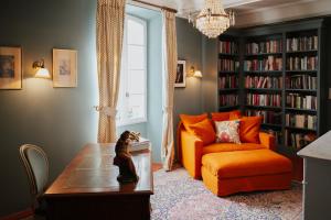 法扬斯La Maison de Platane B&B的客厅配有橙色沙发和桌子