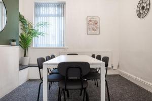 卡迪夫Spacious 4-Bedroom Apt | Sky TV | Pool Table的一间会议室,配有白色的桌子和椅子