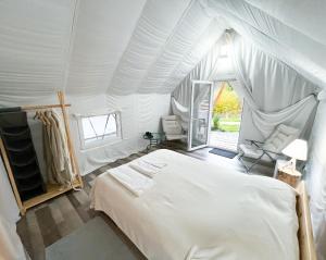 Bughea de JosPINIALE GLAMPING TRIB的帐篷内一间卧室,配有一张床