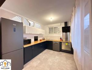 圣布里厄Evasion的厨房配有黑白橱柜和冰箱。