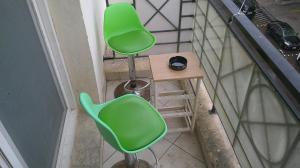迪拜Ruby Star Hostel Loft Bed 21的阳台上配有两张绿色椅子和一张凳子