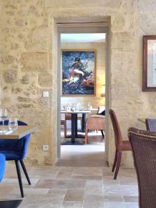 皮斯甘Château Fleur de Roques - Puisseguin Saint Emilion的一间设有桌子和墙上绘画的用餐室