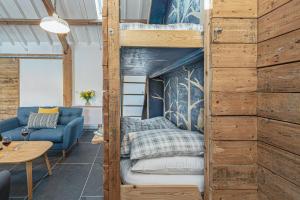 贝图瑟科伊德Snowdonia Glamping Holidays, Seren, Betws-y-Coed的客房设有双层床和沙发。