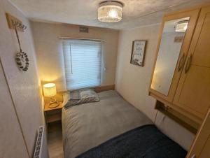 斯凯格内斯Sandy Paws Anderby Creek - Dog Friendly的小房间设有床、书桌和窗户