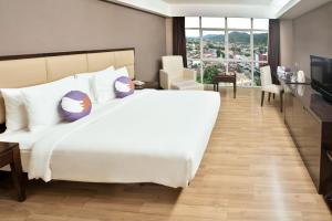 哥伦打洛省FOX Hotel Gorontalo的卧室配有一张白色大床和一张书桌