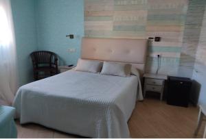 康达Alojamiento Playa de Candás的一间卧室配有一张床、一张桌子和一把椅子