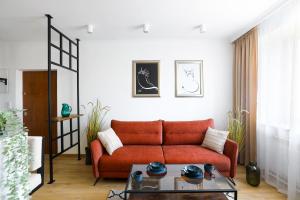 克拉科夫Cozy studio with Air Conditioning for couples, Old Town - Jewish District的客厅配有红色的沙发和桌子