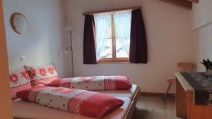 InnerferreraGasthaus Alpenrose的带窗户的客房内的两张床