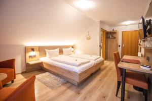奥佩瑙布鲁姆旅馆的一间卧室配有一张大床和一张书桌