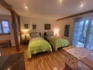腓特烈港兰德古特阿普费罗斯旅馆的一间卧室配有两张带绿色棉被的床