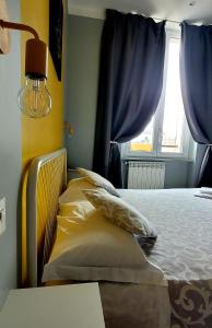 布雷西亚Al Binario Brescia的卧室配有带枕头的床铺和窗户。