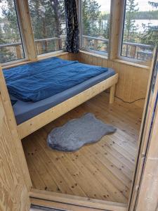 JerfojaurAurora Lodge的木制客房的一张床位,设有窗户