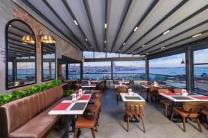 伊斯坦布尔Glamour Hotel Istanbul Sirkeci的餐厅设有桌椅和大窗户。