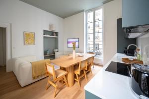 巴黎Noble Suites的厨房以及带桌子和沙发的客厅。