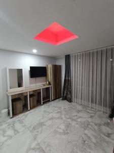 Midyatdara otel的一间带电视的客房内的红色天花板