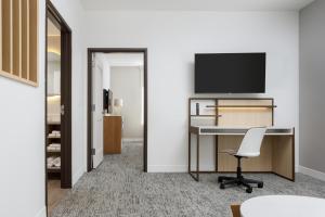 查塔努加TownePlace Suites by Marriott Chattanooga South, East Ridge的办公室设有书桌和墙上的电视