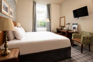 安布尔塞德The Temperance Inn, Ambleside - The Inn Collection Group的配有一张床、一张书桌和一扇窗户的酒店客房