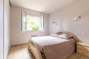 朗通Vacances apaisantes au coeur du Bassin d Arcachon的一间卧室设有一张床和一个窗口