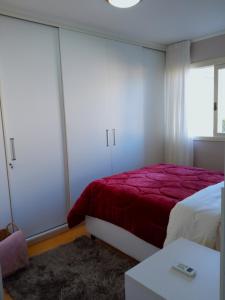 加里波第Apto aconchegante ao lado da Vinícola Garibaldi的一间卧室配有一张带红色毯子的床