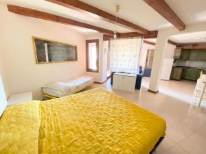 卡珀科达卡瓦洛Capo Coda Cavallo vista mare的一间带黄色床的卧室和一间厨房