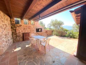 卡珀科达卡瓦洛Capo Coda Cavallo vista mare的庭院配有桌椅和壁炉。