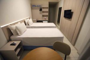 阿拉卡茹Hotel da Costa By Nobile的小房间设有两张床和椅子