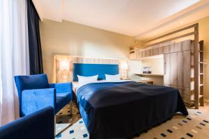 奥斯特西巴德钦诺维茨Baltic Zinnowitz - Hotel mit Meerwasserpool und Thermalbad的酒店客房,配有一张床和两张蓝色椅子