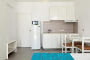 阿依纳帕Lantiana Napa Aparthotel的厨房配有白色橱柜和白色冰箱。