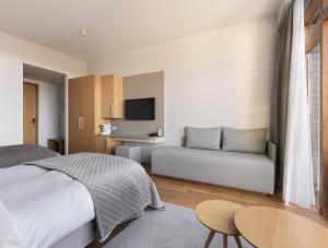 格林达维克Silica Hotel at Blue Lagoon Iceland的一间卧室配有一张床和一张沙发