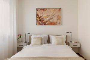 卢加诺Lake Modern Suites - Free Parking的卧室配有白色床,上面有绘画作品