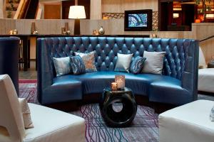 亚特兰大亚特兰大威佛利万丽酒店和会议中心的客厅配有一张蓝色的沙发,配有一张桌子
