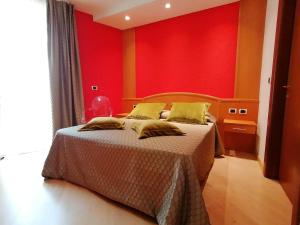 费拉迪普利米罗路易斯酒店的一间卧室配有一张红色墙壁的床