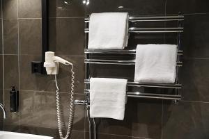 维默比Vimmerby Stadshotell, WorldHotels Crafted的一间带毛巾的浴室和墙上的电话