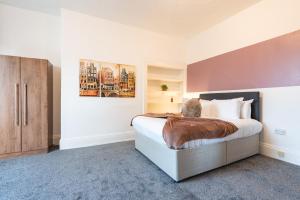 赫尔6 Roomy Bedrooms Favour Spacious Inn - Sleeps 13 Hull Central Location的一间卧室配有一张大床和一个木制橱柜