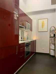 维也纳Feel at home - Self Check In的厨房配有红色橱柜和炉灶烤箱